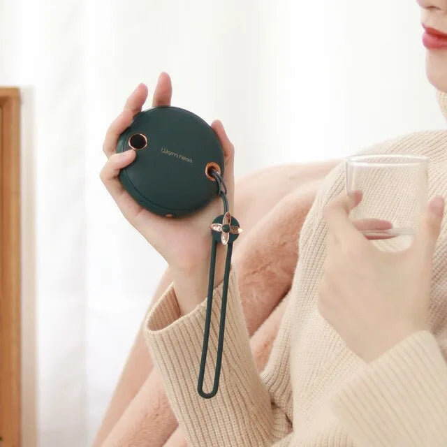 Green hand warmer power bank with digital display showing battery percentage, next to a charging cable.