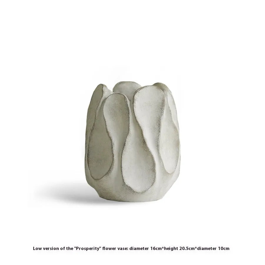 Irregularly shaped art ceramic vase in a low style profile on a wooden surface