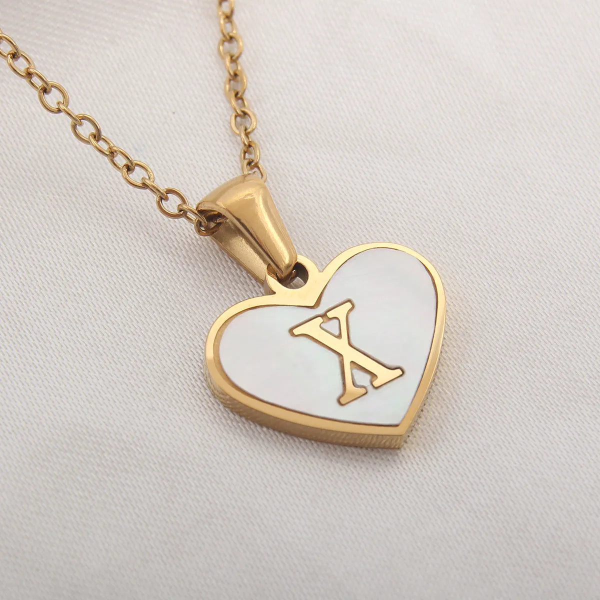 Gold plated chain necklace with a white shell heart-shaped pendant personalised with a single letter initial.