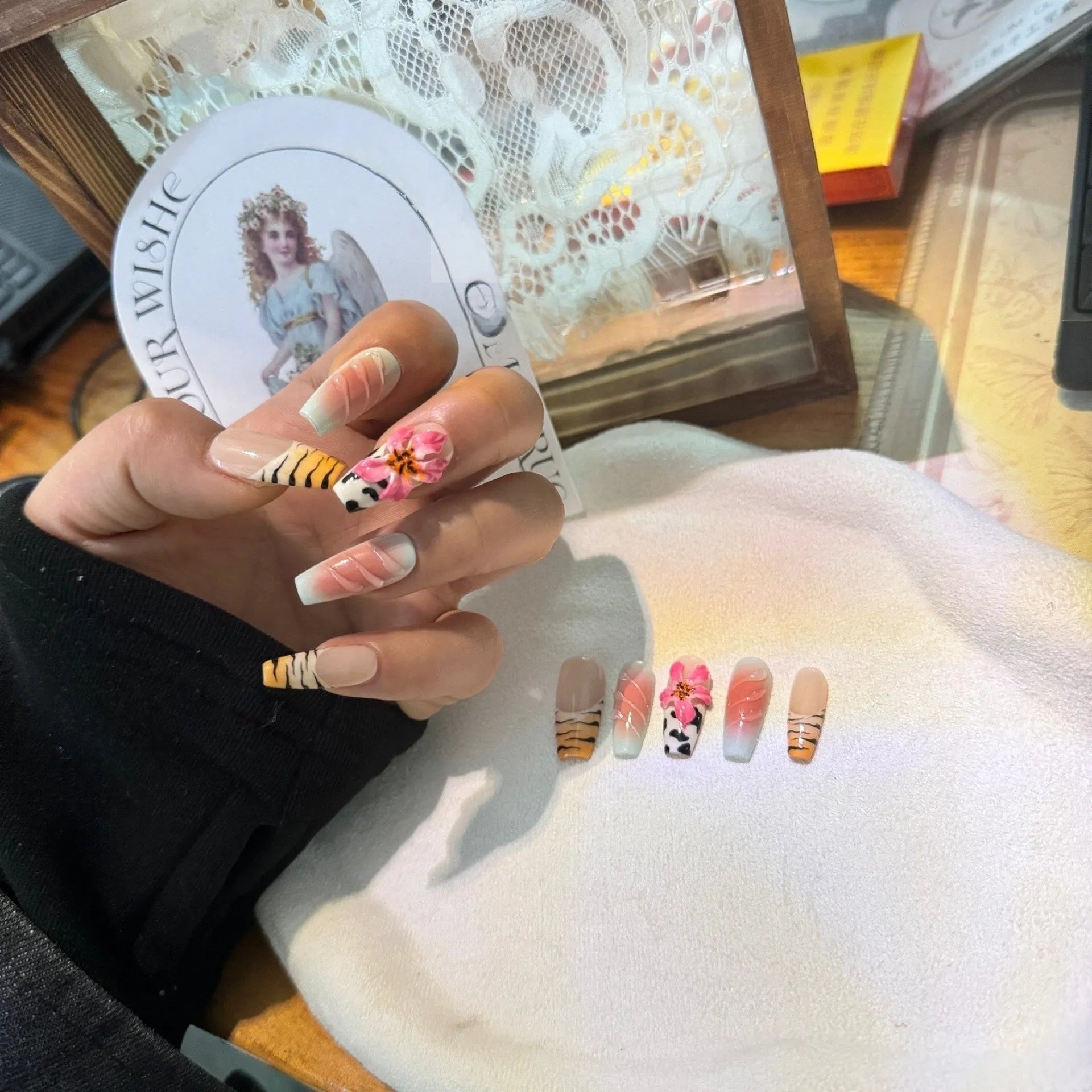 Set of zebra pattern lily hand-carved artificial nail tips with flower and leopard print designs in sizes XS to L