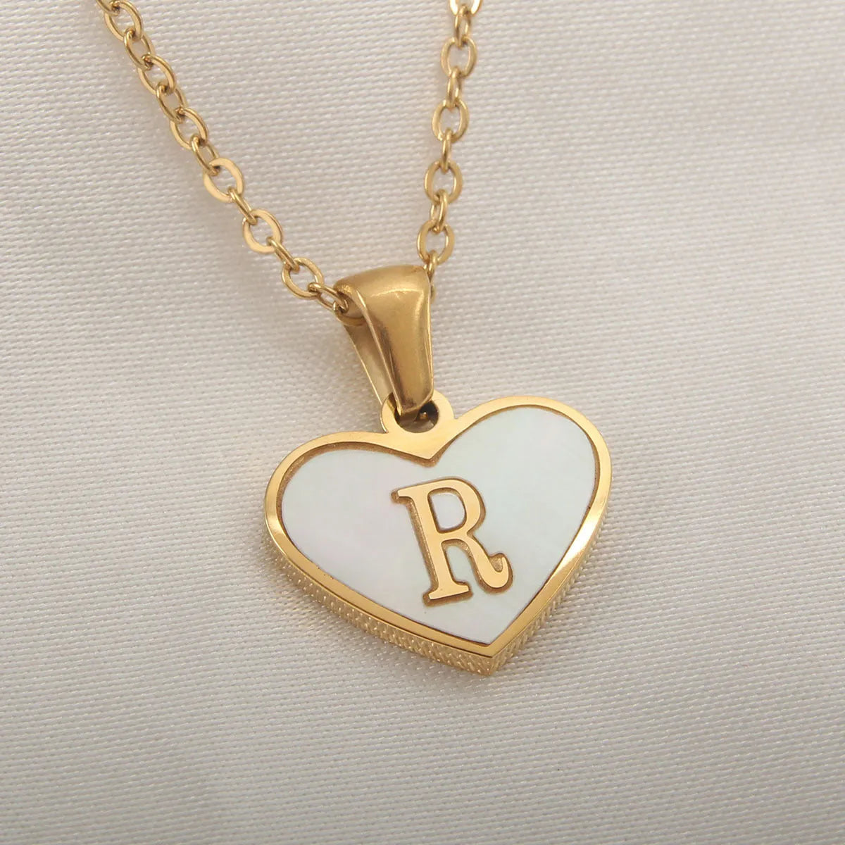 Gold plated chain necklace with a white shell heart-shaped pendant personalised with a single letter initial.