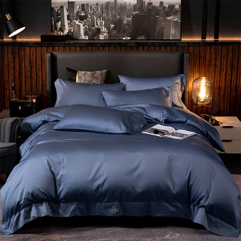 Four-piece cotton satin quilted bedding set with duvet cover, sheet, and pillowcases in a bedroom setting