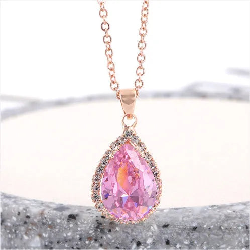 Water drop shaped geometric pendant necklace with rhinestone detailing in rose gold pink colour