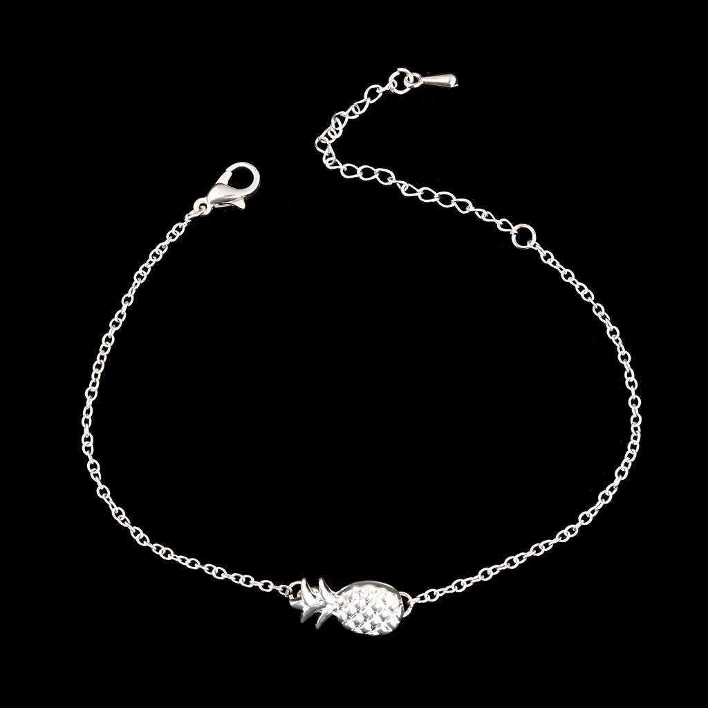 Close-up of a gold-colour alloy bracelet shaped like a pineapple on a wrist.