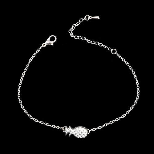 Women's alloy bracelet with a pineapple charm in gold or silver tone on a wrist.