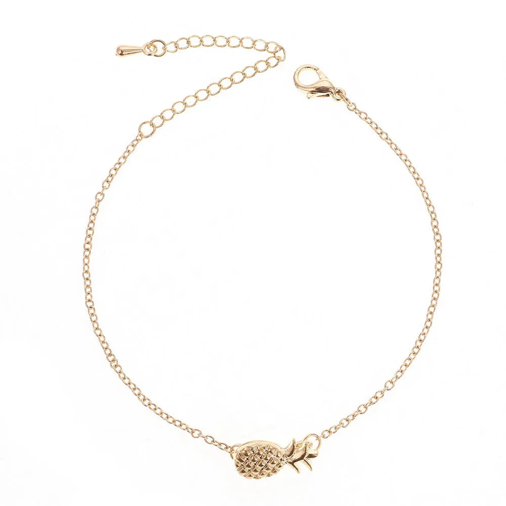 Close-up of a gold-colour alloy bracelet shaped like a pineapple on a wrist.