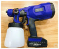Blue cordless automatic paint spray gun with 800ml can and 1.8mm nozzle on a workbench.
