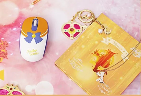 Pink Sailor Moon wireless mouse with USB receiver on a desk.