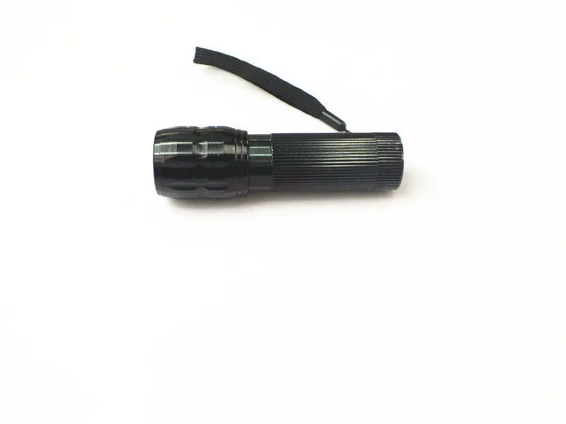 Black mini LED flashlight with telescopic head and tail push button switch on plain background