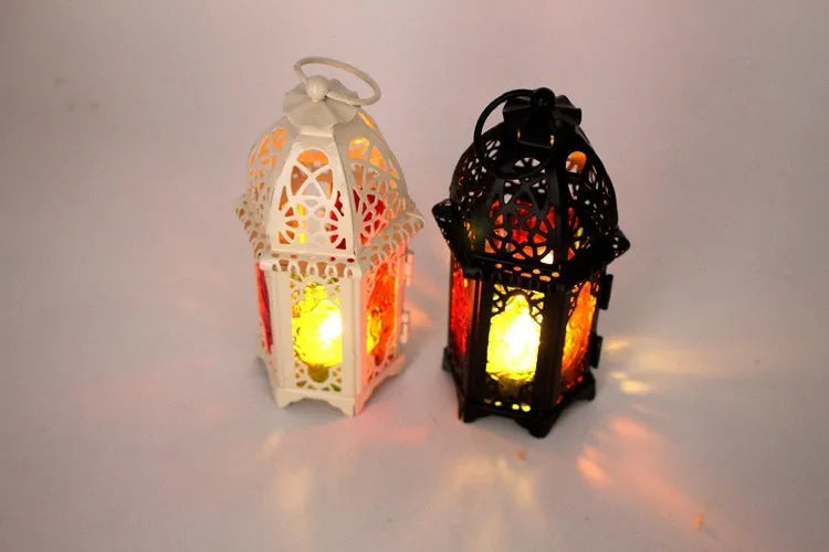 Handmade wrought iron hanging candle holder in black, 16cm tall and 7cm diameter, with a lit candle