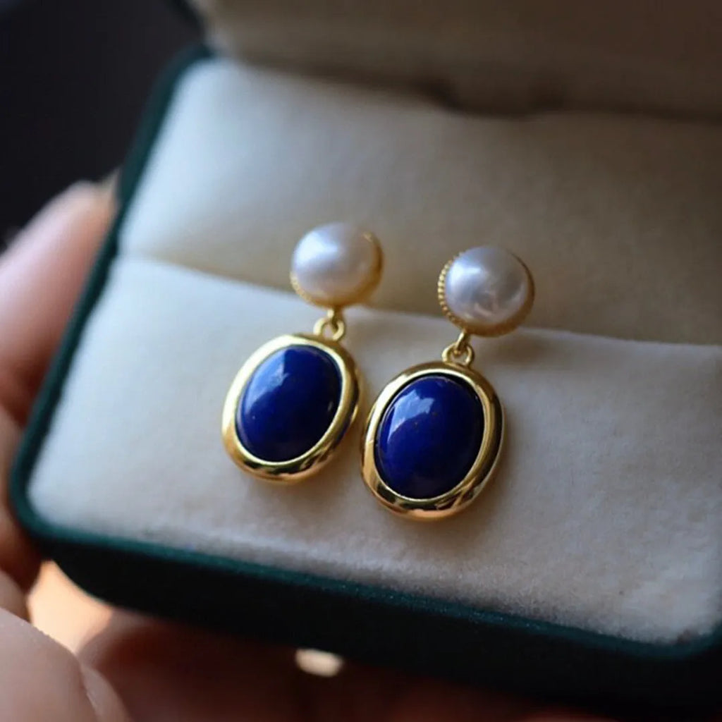 A pair of simple 925 silver stud earrings with a blue lapis lazuli pearl and auspicious patterns.
