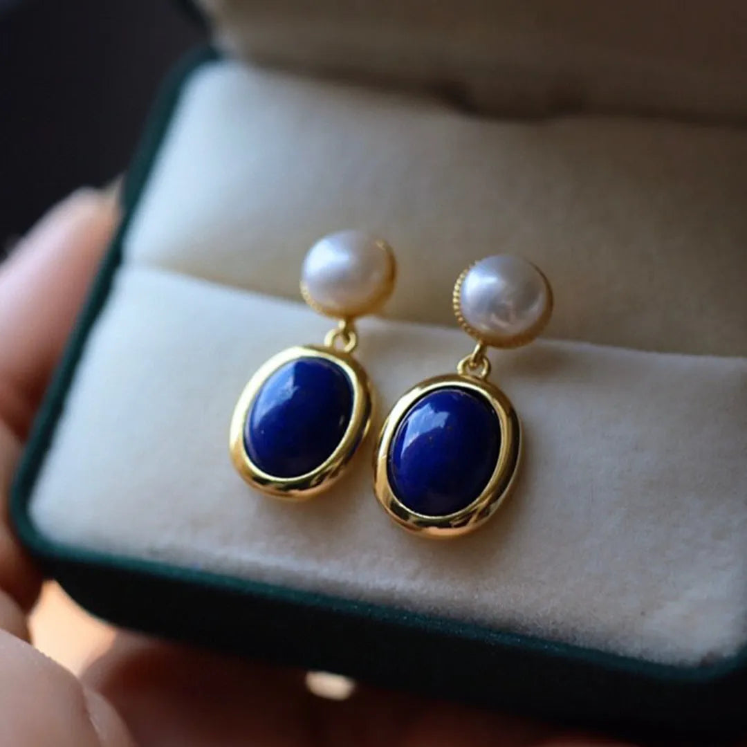 A pair of simple 925 silver stud earrings with a blue lapis lazuli pearl and auspicious patterns.