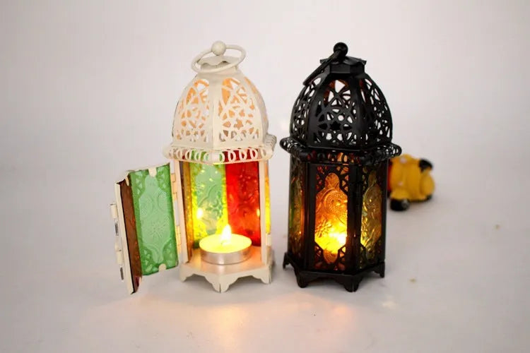 Handmade wrought iron hanging candle holder in black, 16cm tall and 7cm diameter, with a lit candle