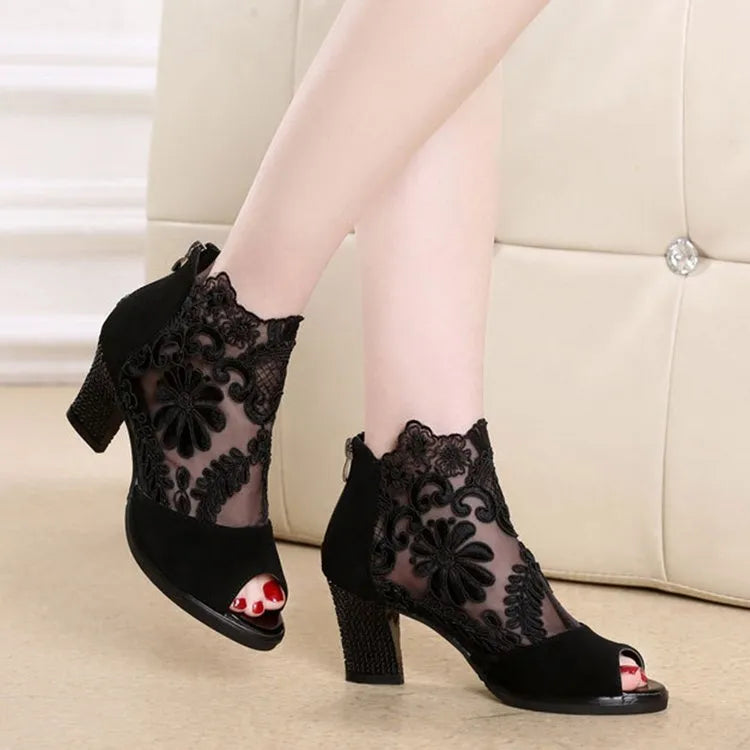 Black women's gladiator sandals with lace upper, square heel, zip closure, and peep toe.