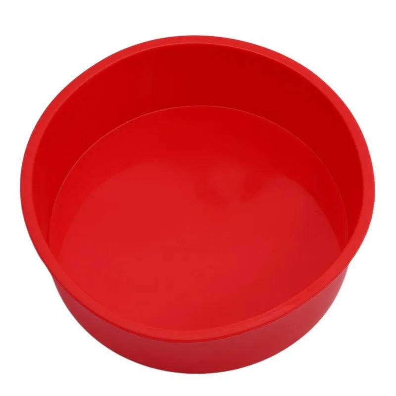 Set of three round red silicone cake moulds in 4-inch, 6-inch, and 8-inch sizes on a baking tray.