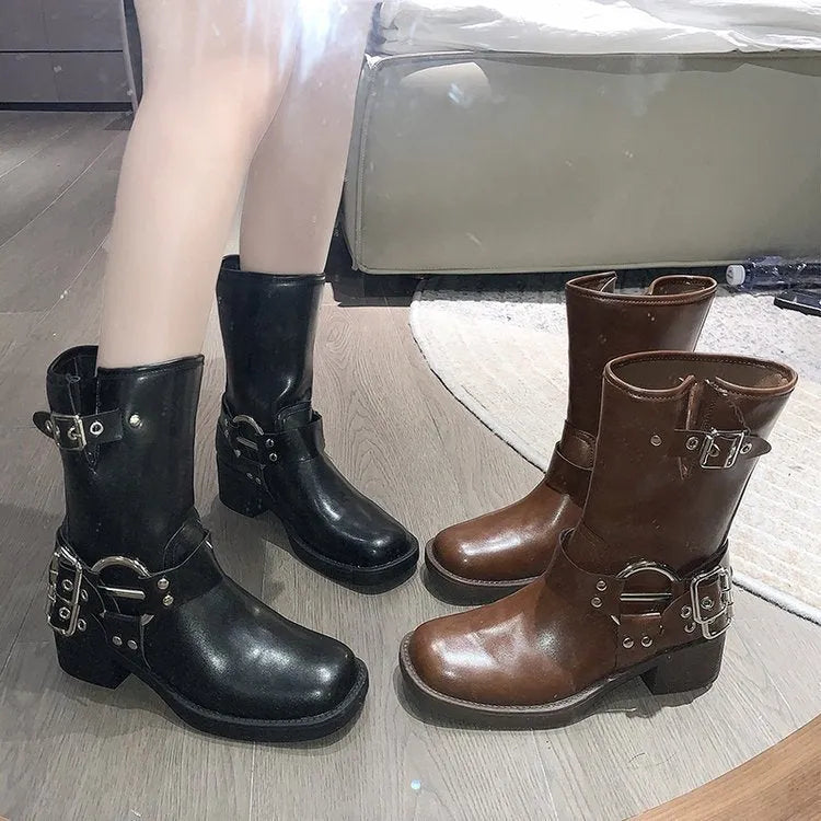 Women's black platform boots with belt buckle detail showing middle calf length