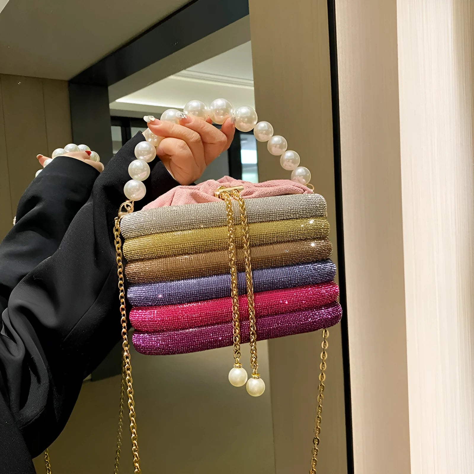 Women's black one-shoulder crossbody bag with pearl beading on the front.