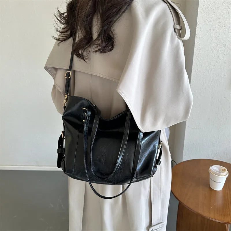 Soft PU retro commuter tote bag with synthetic leather lining, double shoulder straps, and zip hidden pocket in black or brown.