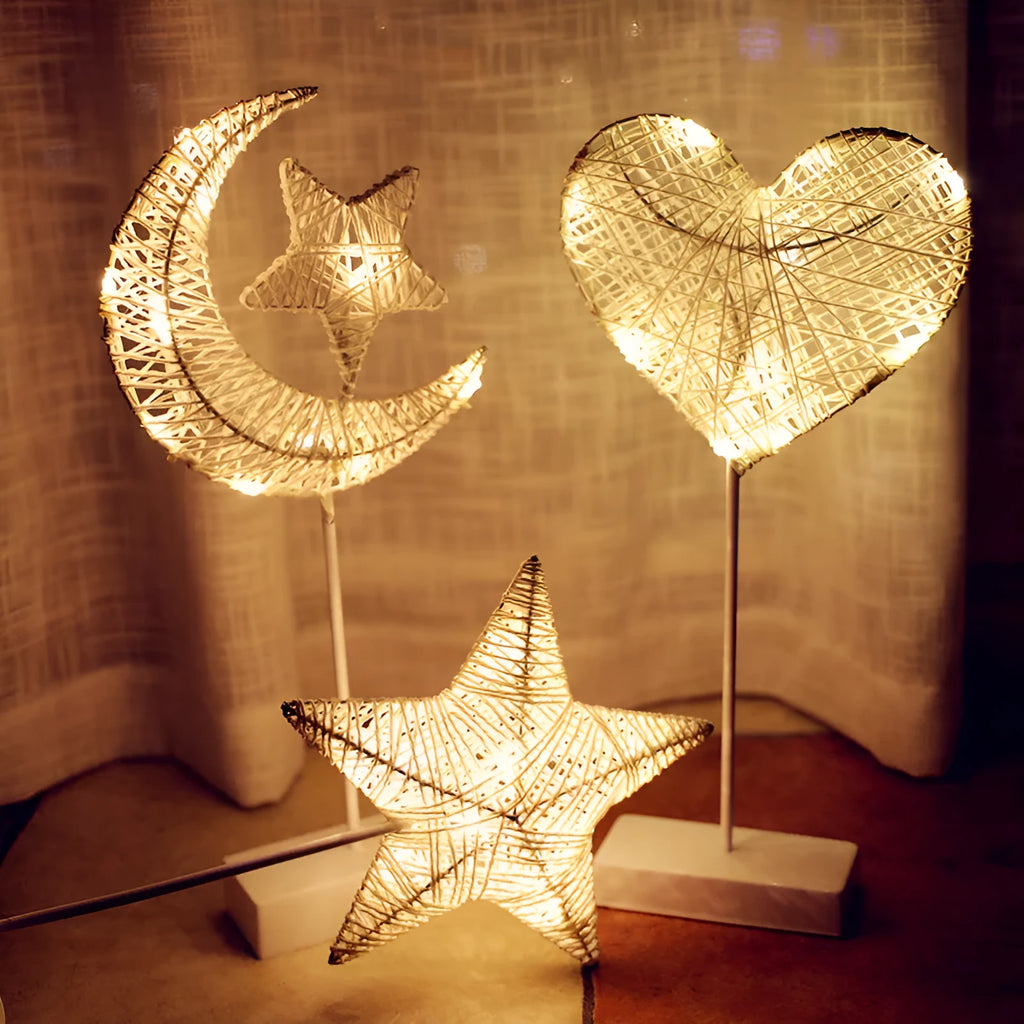 Rattan woven star-shaped LED table lamp with copper wire details on a table.