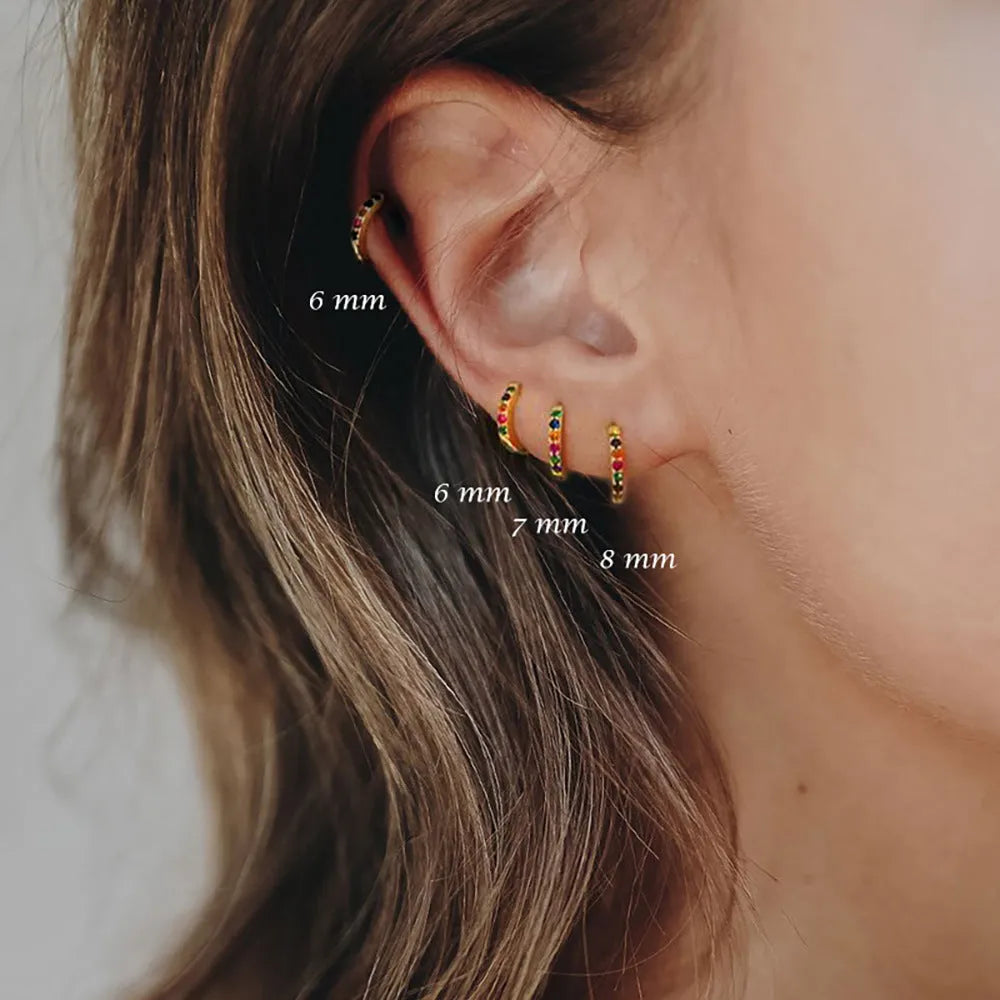A pair of round geometric stud earrings with a perforated design in a gold electroplated finish.