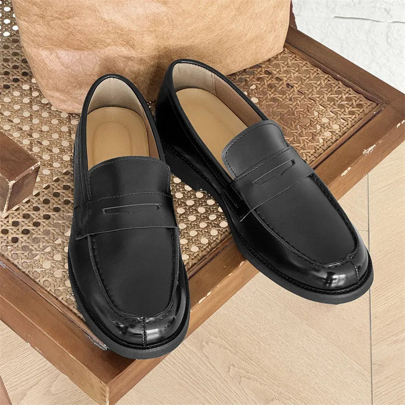 Black men's slip-on derby leather shoes with a rubber sole on a white background