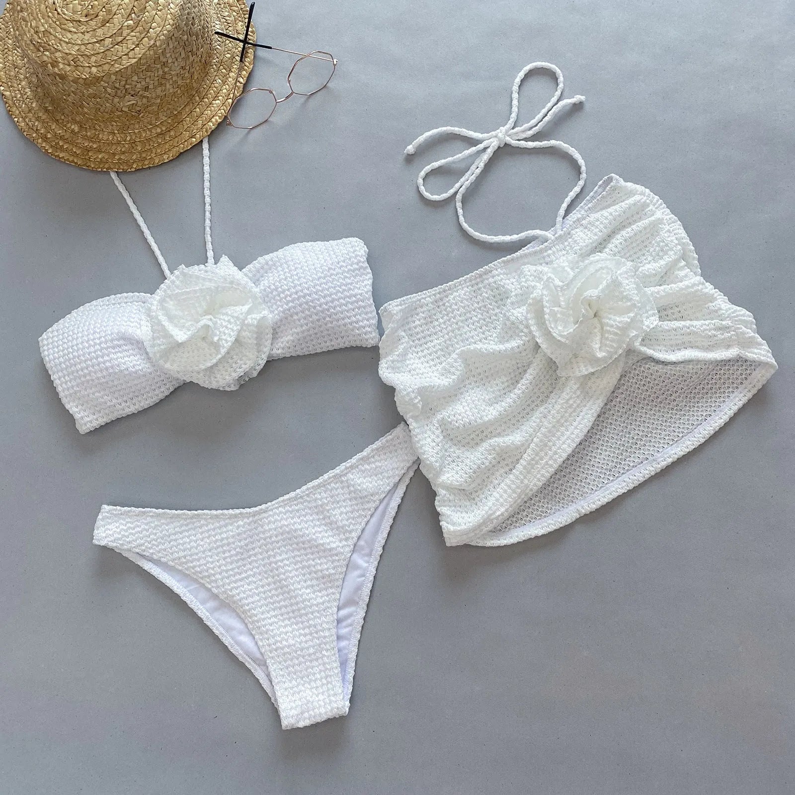 Women's white three-piece bikini swimsuit with 3D flower split detail on mannequin