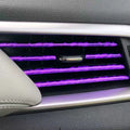 Ten PVC car air conditioning outlet trim clips in assorted colours on a dark dashboard