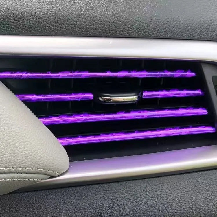 Ten PVC car air conditioning outlet trim clips in assorted colours on a dark dashboard