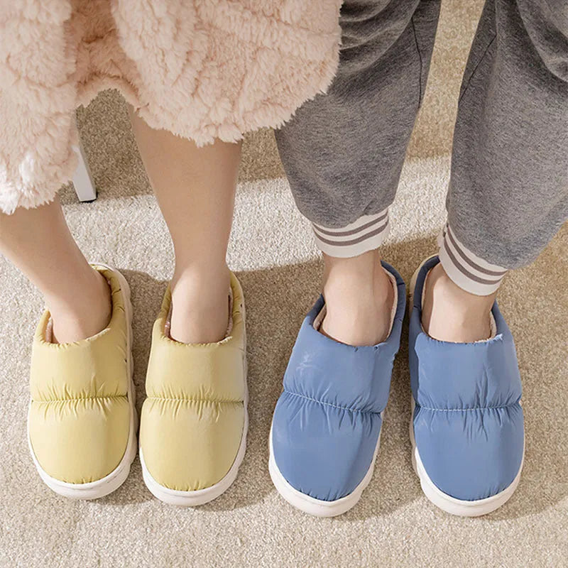 A pair of thick-soled indoor slippers with an artificial leather upper and soft plush lining, shown in a choice of colours.