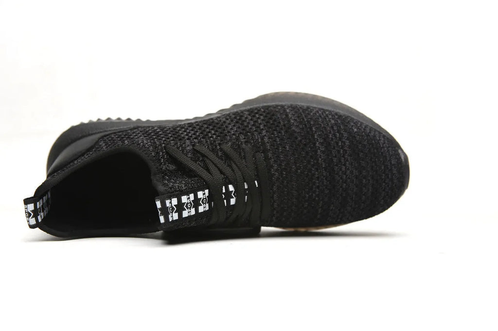 Men's black steel toe safety shoes with low-cut design on a work surface