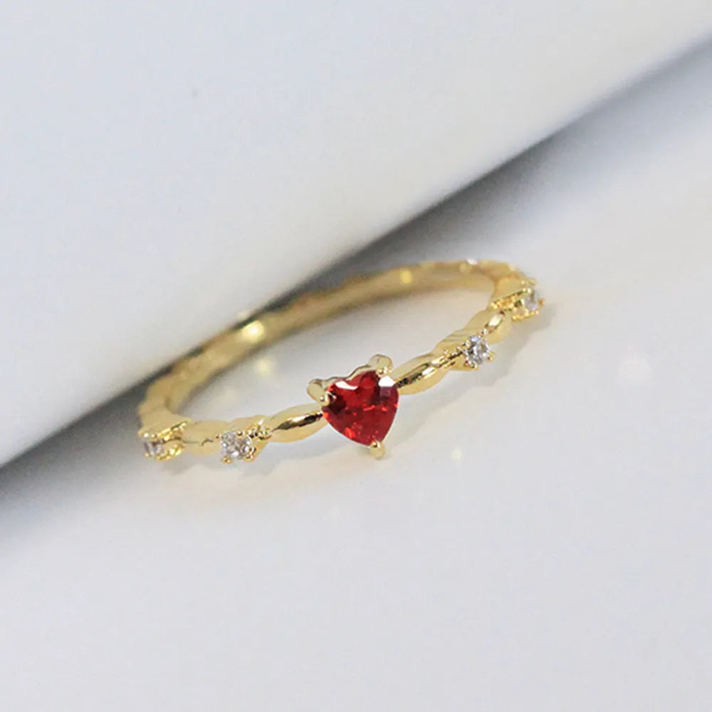 Gold or silver peach heart-shaped ring with clear zircon stones on a copper band.