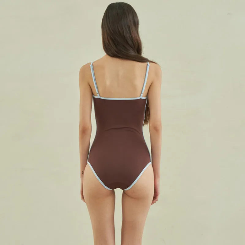 Brown women's one-piece swimsuit with triangle halter neck on a mannequin.