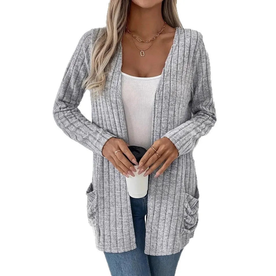 A solid colour long sleeve cardigan with pockets, shown in loose fit on a model.