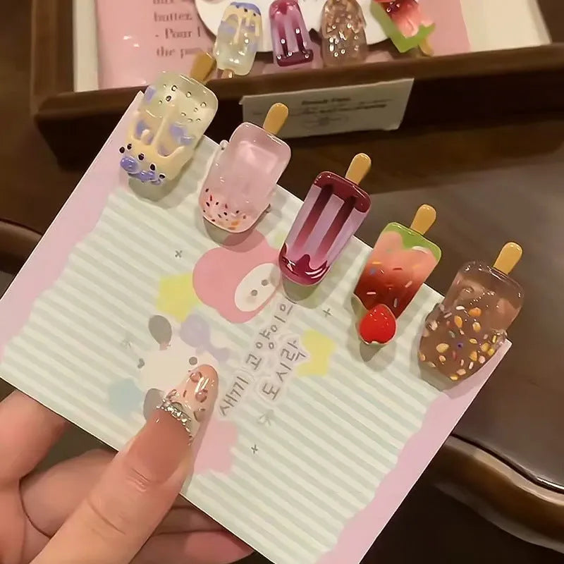 A resin hair clip shaped and coloured like a cartoon ice cream barrette, shown on a side clip.