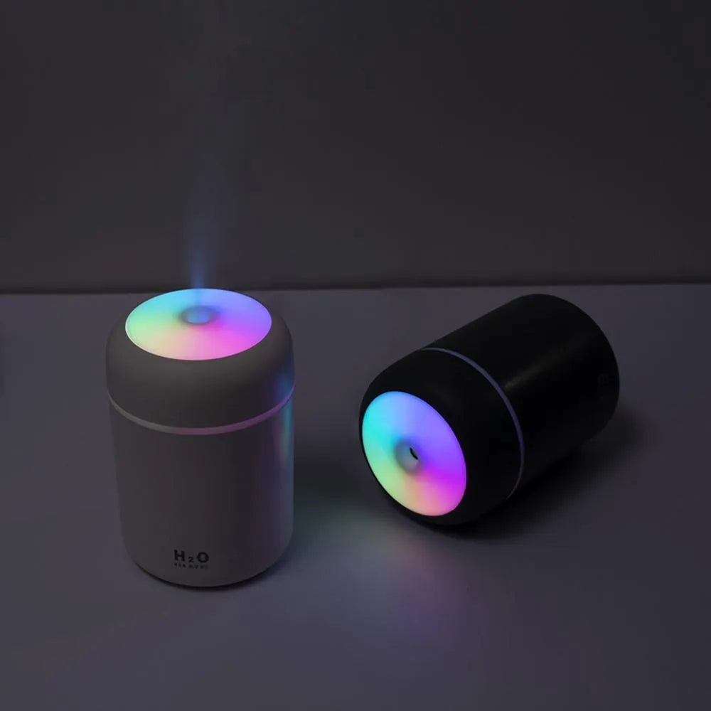 Pink USB desktop humidifier with colourful lights and 300ml water tank on wooden surface