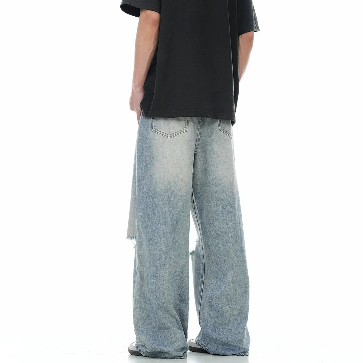 Men's blue distressed straight-leg retro jeans with a zip fly on a plain background.