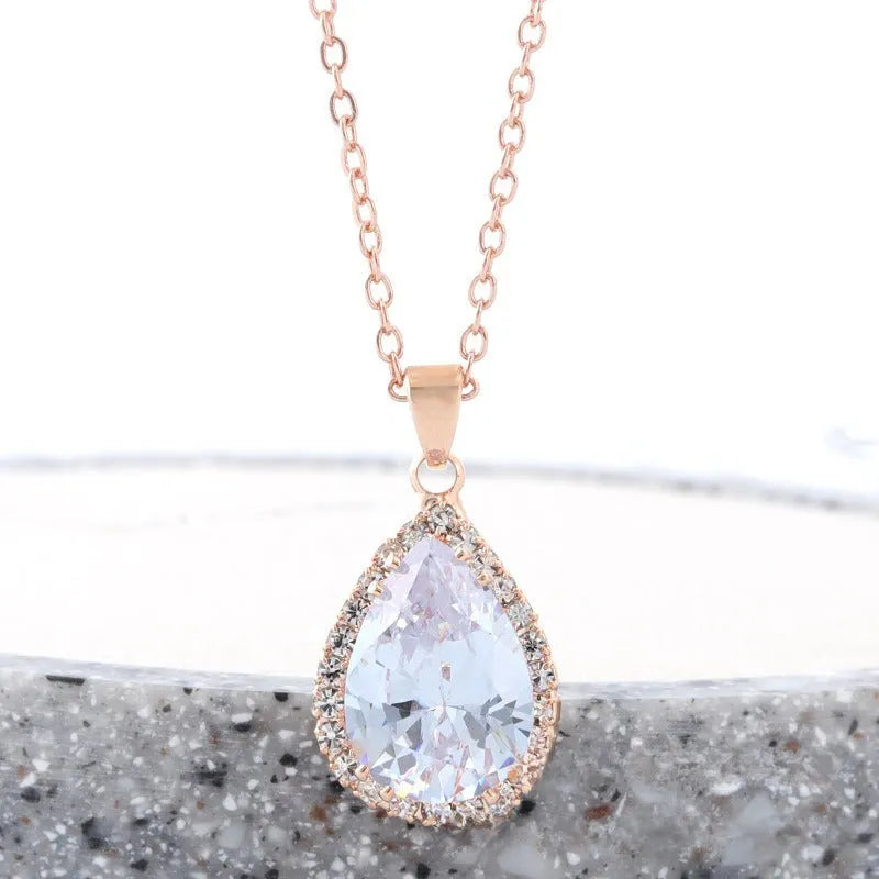 Water drop shaped geometric pendant necklace with rhinestone detailing in rose gold pink colour