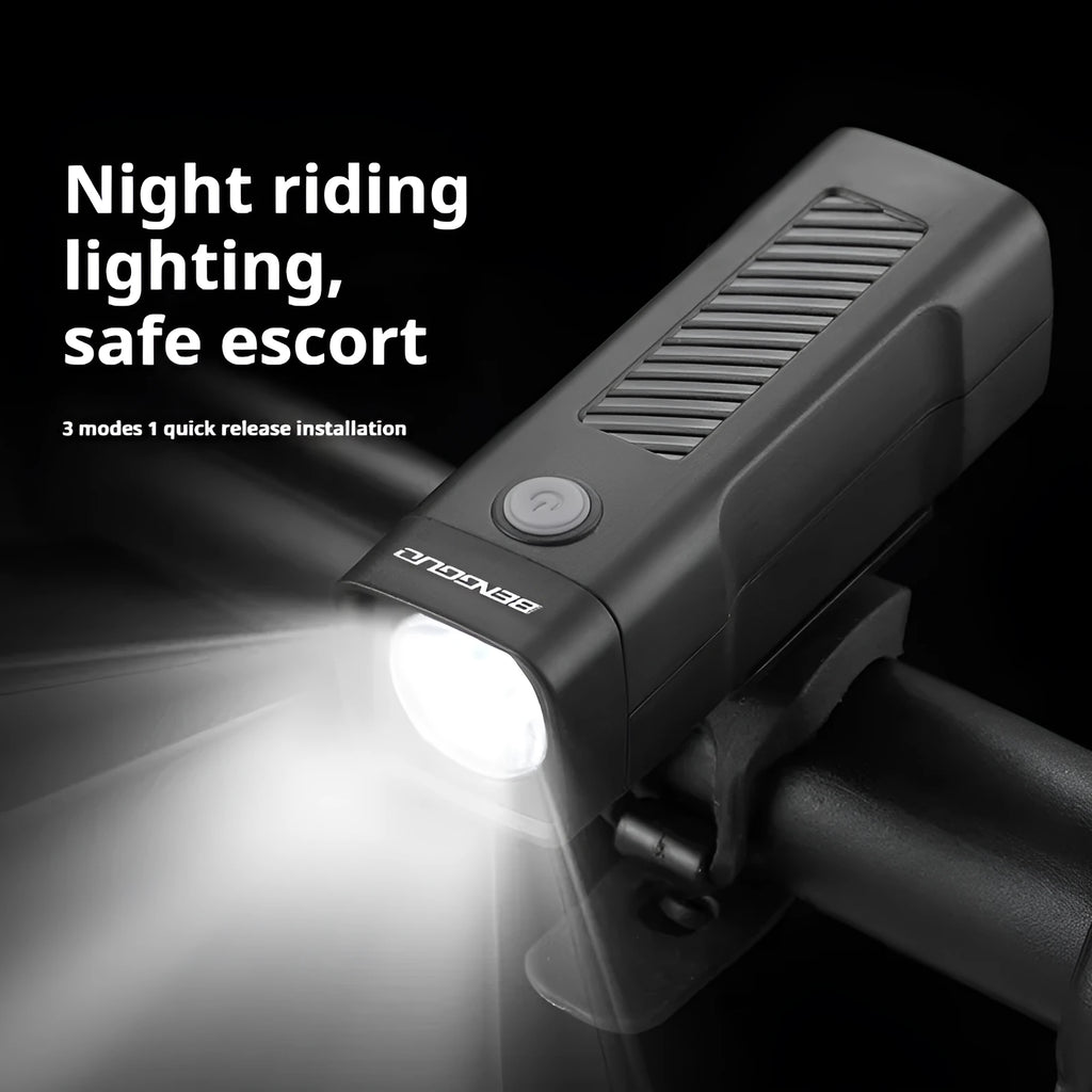 A black USB rechargeable bicycle headlight with a quick-release strap mount on a handlebar.