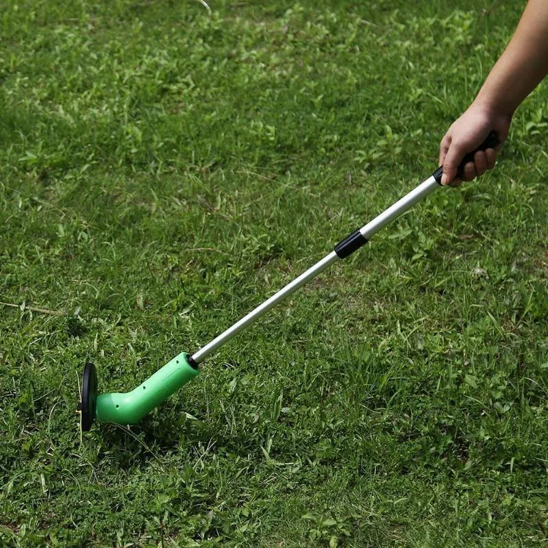 Cordless handheld grass trimmer with extension pole and protective shield on a garden lawn