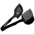 A black or green plastic tomato slicing holder on a kitchen worktop.