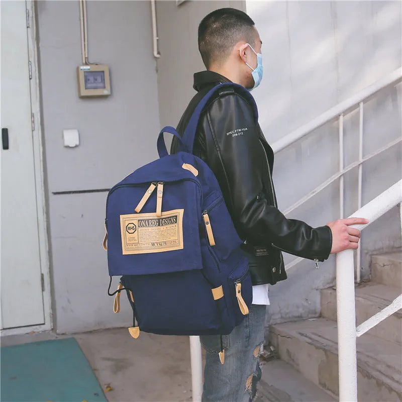 Korean canvas backpack in black with rain cover, double shoulder straps, and zipped internal pockets for travel and campus use