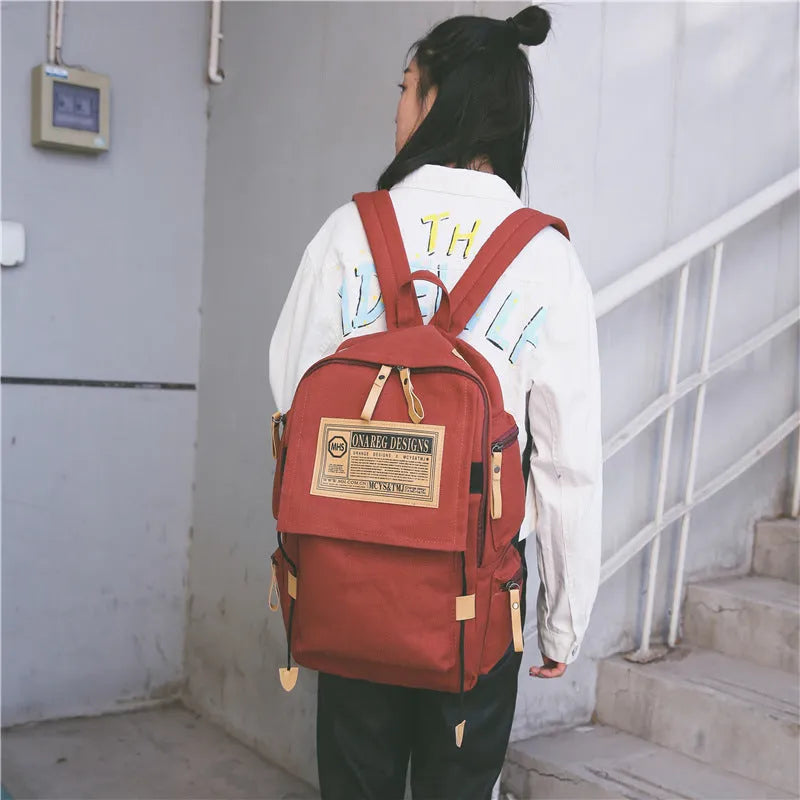 Korean canvas backpack in black with rain cover, double shoulder straps, and zipped internal pockets for travel and campus use