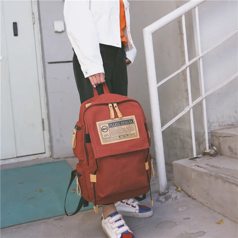 Korean canvas backpack in black with rain cover, double shoulder straps, and zipped internal pockets for travel and campus use