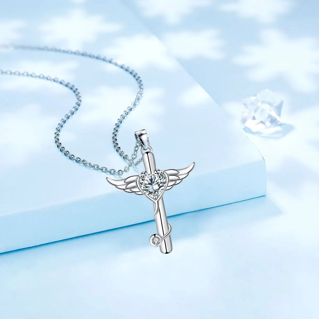 Close-up of a women's necklace with a charm combining a cross, stethoscope, and wings, in a choice of red or white electroplated finish.