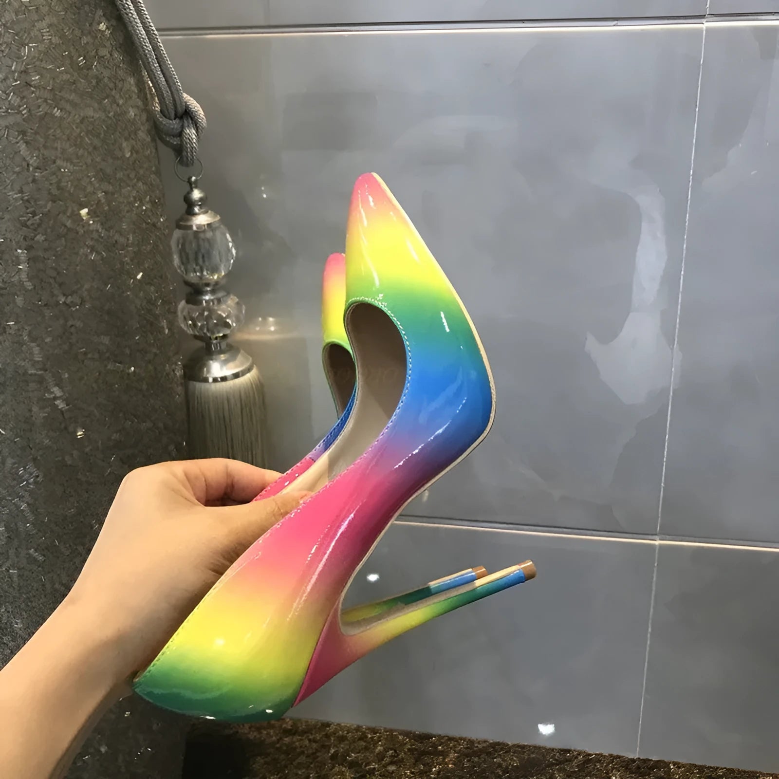 Rainbow glossy patent leather women's ultra-high heel shoe with pointed toe and thin heel.