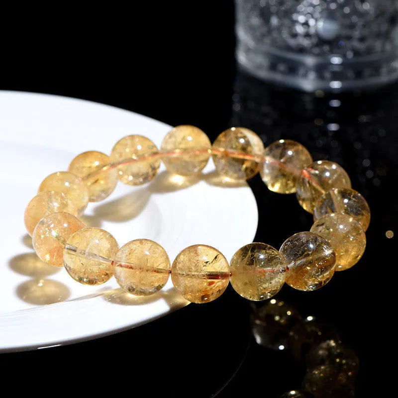 Natural yellow citrine gemstone bracelet with geometric beads on a white background.