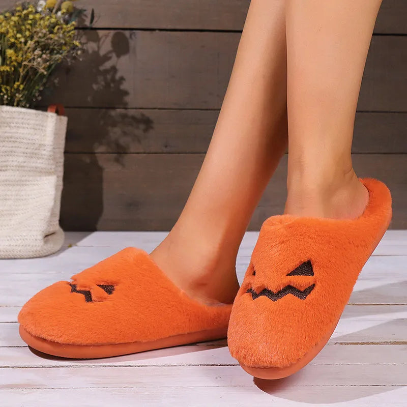 Orange Halloween pumpkin slippers with plush lining and a textured non-slip PVC sole.