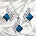 Alloy pendant necklace and matching earrings with glass ornamentation and cross chain design