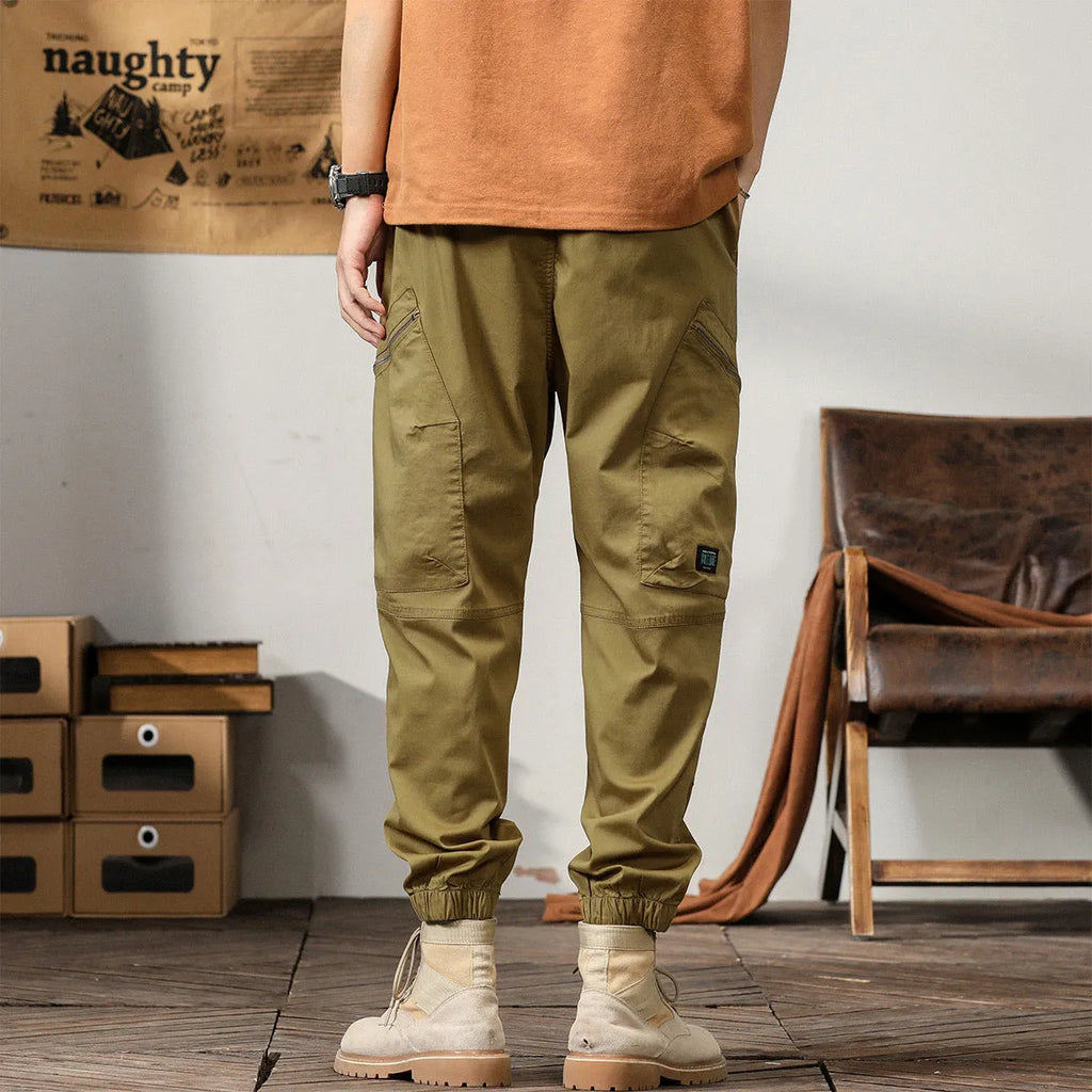 Men's khaki cotton tapered harem pants with a small ankle opening and mid-waist design on a neutral background.