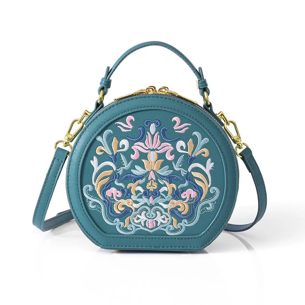 National style round crossbody bag in khaki PU leather with embroidery and sewing line details, shown on a plain background